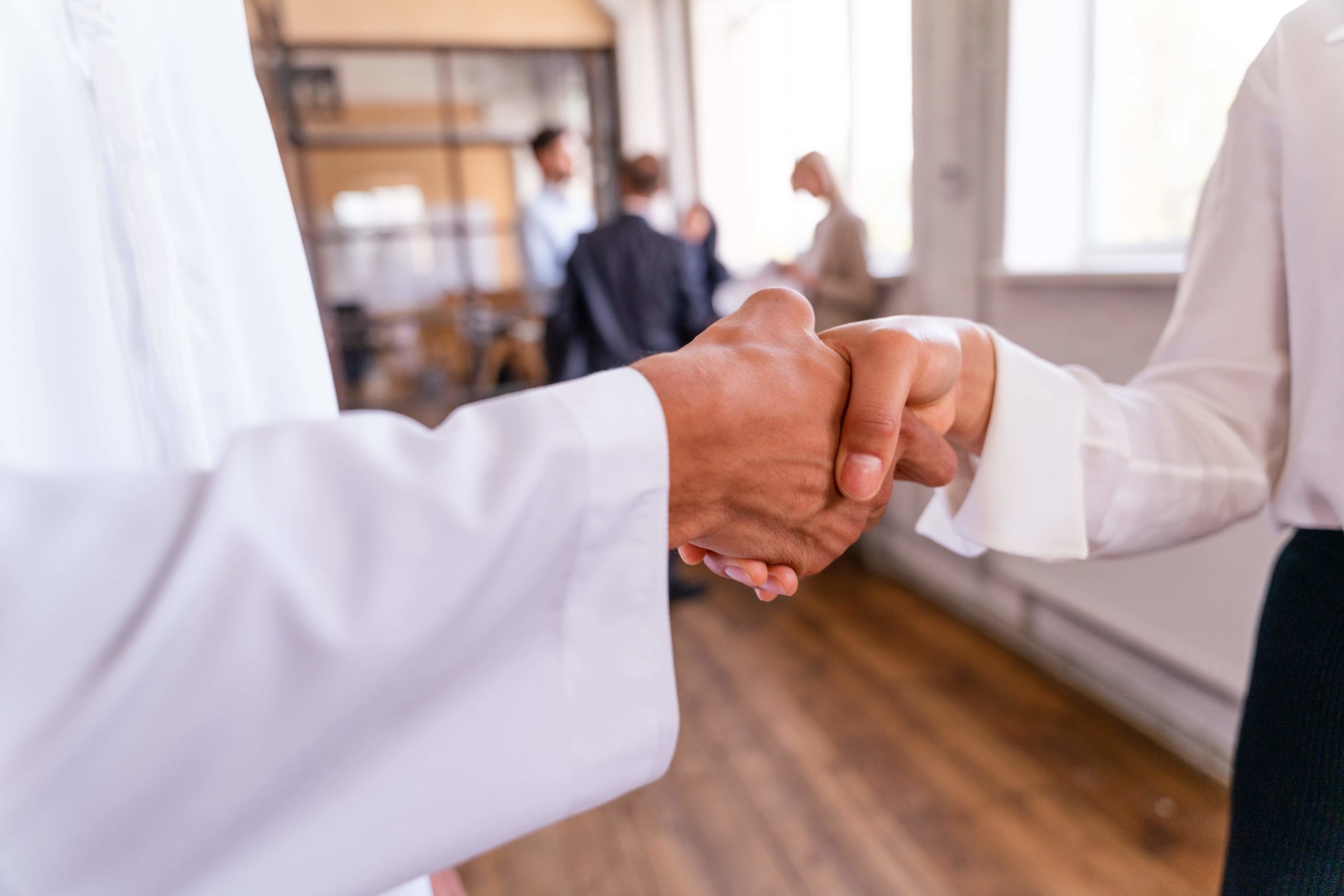 Sostenibilità enti religiosi Fotografia del dettaglio della stretta di mano tra un prete e una fedele